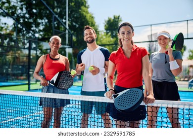 Group of happy athletic friends on padel outdoor tennis court looking at camera. - Powered by Shutterstock