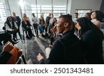 A group of happy and attentive individuals participating in an engaging conference session, showing enthusiasm and connection in a modern setting.