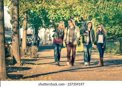 Group Of Happy Best Friends With Alternative Fashion Look Walking At The Park - Hipster Tourists Having Fun Outdoors In Sunny Winter Day - University Students During A Break Hanging Out Together