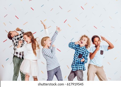 Group Of Happy Boys And Girls Pretending To Sing At A Party