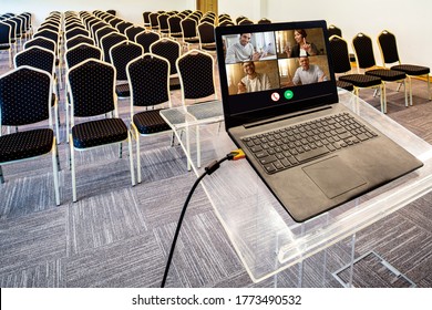 Group Of Happy Business Coworkers Having Video Call Over Laptop In Empty Conference Hall. 