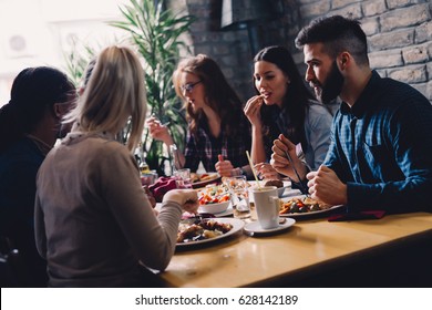 Group of happy business people eating together in restaurant