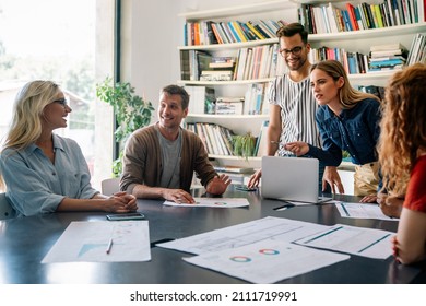 Group of happy business people working together on project in office. - Shutterstock ID 2111719991