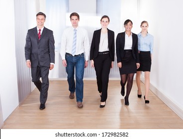 Group Of Happy Businesspeople Walking Towards Camera