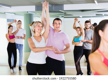 Group Of Happy Cheerful Positive Smiling Young Adults Dancing Salsa In Club