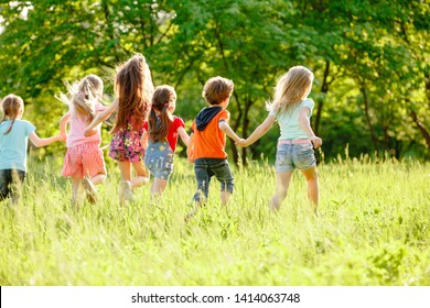 A group of happy children of boys and girls run in the Park on the grass on a Sunny summer day . The concept of ethnic friendship, peace, kindness, childhood - Shutterstock ID 1414063748