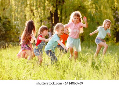 A group of happy children of boys and girls run in the Park on the grass on a Sunny summer day . The concept of ethnic friendship, peace, kindness, childhood - Shutterstock ID 1414063769