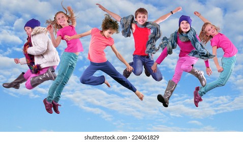 Group of happy children exercising, jumping and having fun in the bright blue cloudy sky Childhood, happiness, active lifestyle concept - Powered by Shutterstock