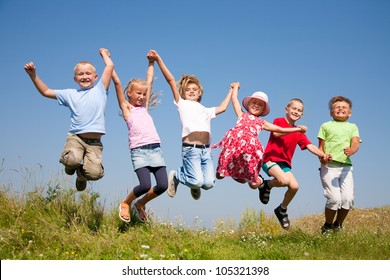 Group  Happy Children  Jumping On Summer Meadow Against Blue Sky