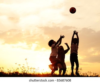 Group of happy children playing with ball on meadow, sunset, summertime - Shutterstock ID 83687608