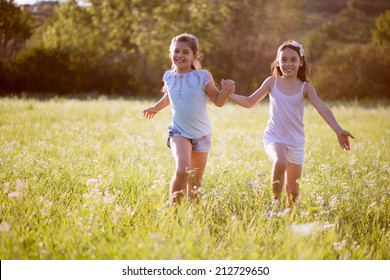 Group Of Happy Children Playing On Meadow