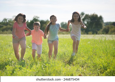 Group Of Happy Children Playing On Meadow