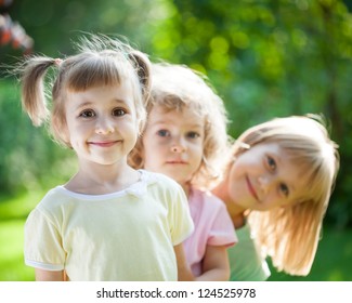 Group Of Happy Children Playing Outdoors In Spring Park