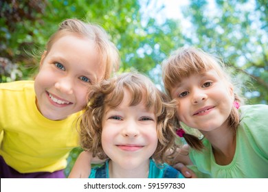 Group Of Happy Children Playing Outdoors. Kids Having Fun In Spring Park