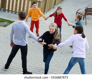 Group Of Happy Children Playing Red Rover Outdoors