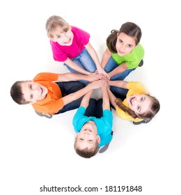 Group Of Happy Children Sitting On The Floor In A Circle Holding Hands And Looking Up - Isolated On White.