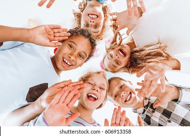 Group Of Happy Children Waving At The Camera