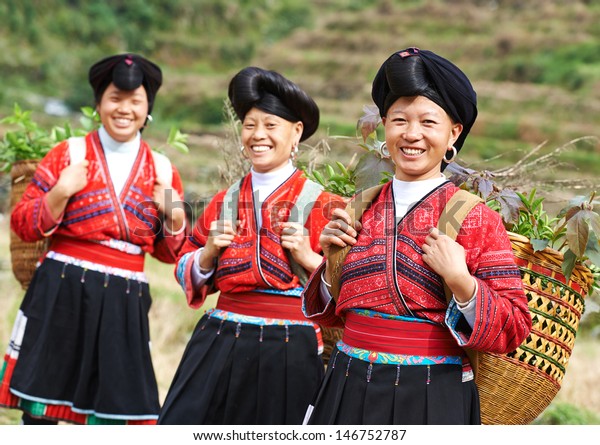 Group of happy chinese minority woman Yao in\
traditional dresses\
outdoors