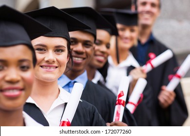 Group Of Happy College Graduates Standing In A Row