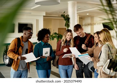 Group of happy college students reading test results while standing in a hallway.  - Shutterstock ID 2025379490
