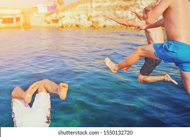 Group of happy crazy people having fun jumping in the sea water from boat. Friends jump in mid air on sunny day summer pool party at diving holiday. Travel vacation, friendship, youth holiday concept - Powered by Shutterstock