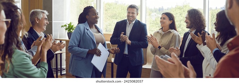 Group of happy diverse business people applauding to female speaker standing in a circle in meeting room. Successful company employees clapping a colleague on business training or conference. Banner. - Powered by Shutterstock