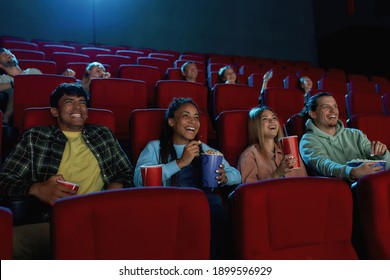 A group of happy diverse friends laughing while watching movie together, sitting in cinema auditorium. Entertainment and people concept. Horizontal shot - Powered by Shutterstock