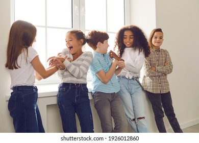 Group of happy diverse friends playing, tickling each other, laughing, having fun during school recess or party at home. Children's social interaction with peers, intercultural kids community concepts