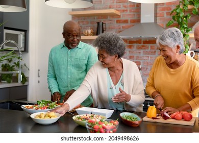 Group of happy diverse senior male and female friends cooking together at home. cooking and socialising with friends at home. - Powered by Shutterstock