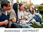 Group of happy diverse students sitting on grass and studying with laptop on university campus. Student life, high school. Motivation and learning.     