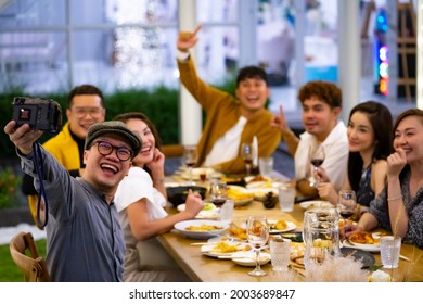 Group of Happy diversity Asian millennial people friends enjoy outdoor dinner party and using digital camera photography together. Reunion friendship meeting celebration party and night life concept. - Powered by Shutterstock