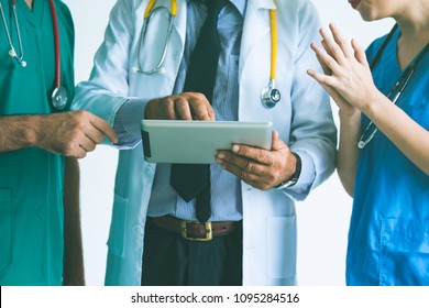 Group Of Happy Doctor Surgeon And Nurse With Tablet In Meeting On White Background, Healthcare And Medical Concept