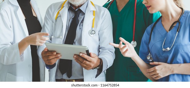 Group of happy doctor surgeon and nurse with tablet in meeting on white background, Healthcare and medical concept - Powered by Shutterstock