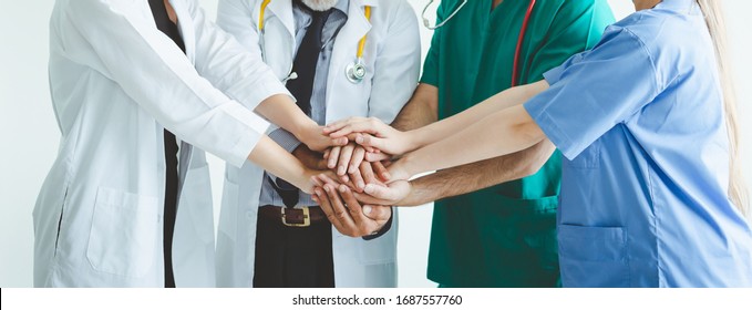 Group Of Happy Doctor Surgeon And Nurse Putting Their Hand Together For Teamwork In Meeting On White Background, Healthcare And Medical Concept