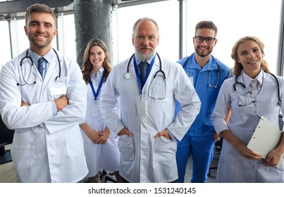 Group of happy doctors in hospital corridor, portrait.