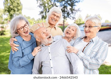 Group of happy elderly people bonding outdoors at the park - Old people in the age of 60, 70, 80 having fun and spending time together, concepts about elderly, seniority and wellness aging - Powered by Shutterstock