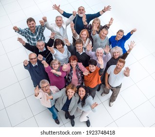 Group Of Happy Elderly People Standing With Their Hands Up .