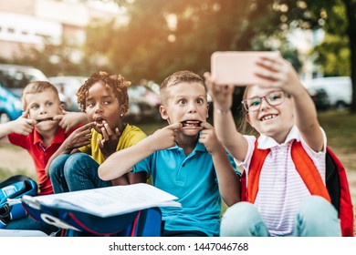 Group of happy elementary school students taking selfie. Primary education, friendship, childhood, and technology concept. - Powered by Shutterstock