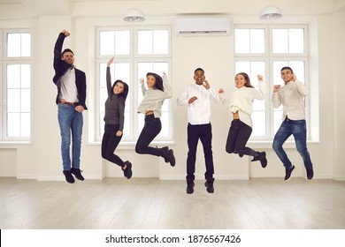 Group Of Happy, Emotional, Energetic People Jumping All Together In New Office. Intercultural Team Of Excited Friends, Students, Business Startup Members Or Young Company Coworkers Celebrating Success