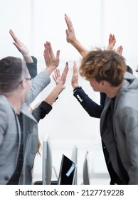 Group Of Happy Employees Giving Each Other A High Five.