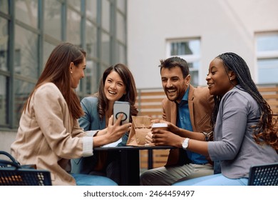 Group of happy entrepreneurs watching something funny on cell phone during coffee break outdoors.  - Powered by Shutterstock