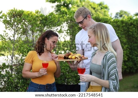 Similar – Gruppe von Freunden, die bei einem Sommergrill kochen.