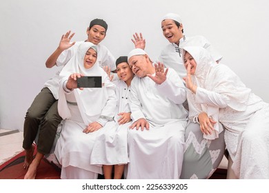 Group of happy family muslim take a selfie together or having virtual meeting using smartphone during the Eid Mubarak ramadan celebration.  - Shutterstock ID 2256339205
