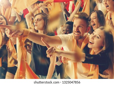 Group of happy fans are cheering for their team victory - Shutterstock ID 1325047856