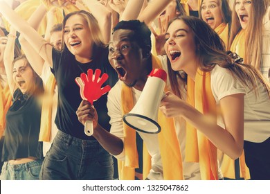 Group of happy fans are cheering for their team victory - Shutterstock ID 1325047862