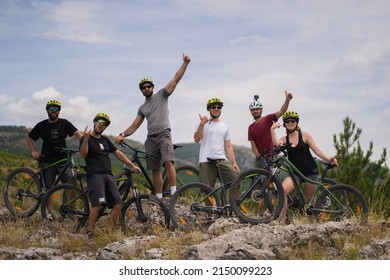 Group of happy friends with bikes are posing on topo of the hill - Powered by Shutterstock