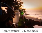 Group of happy friends cheering with tropical cocktails and beers at beach party, Young people having fun in Goa, Youth and summer vacation concept	