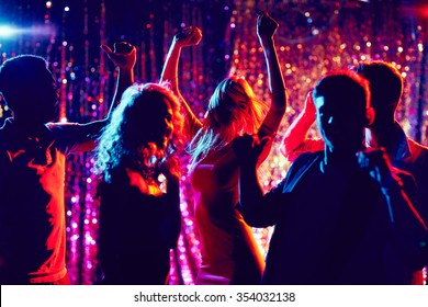 Group of happy friends dancing at party