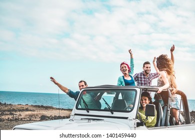 Group Of Happy Friends Doing Excursion On Desert In Convertible 4x4 Car - Young People Having Fun Traveling Together - Friendship, Tour, Youth Lifestyle And Vacation Concept - Focus On Right Guys