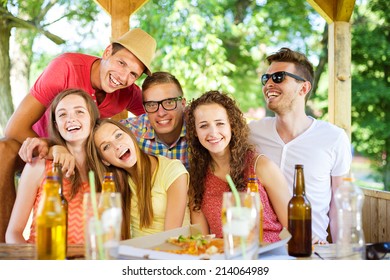 Group Of Happy Friends Drinking And Having Fun In Pub Garden